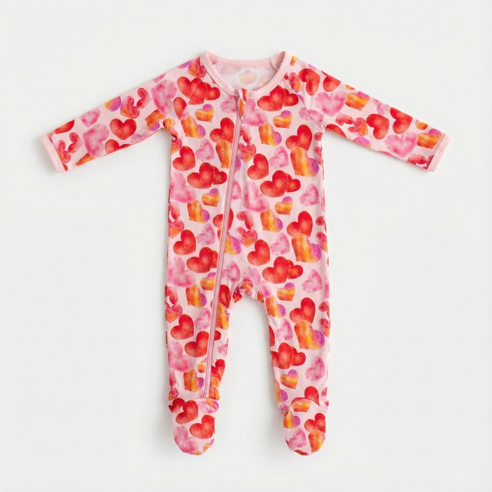 Pink baby onesie with heart pattern on a white background