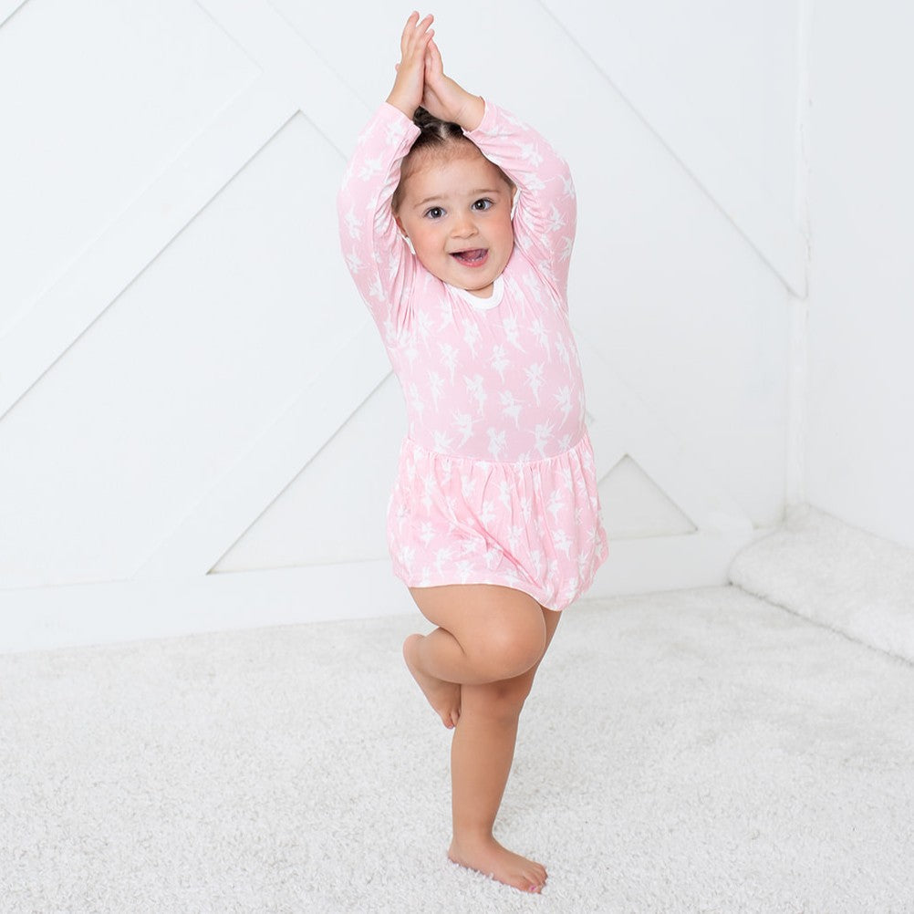 Child wearing a pink dress with white polka dots on a white background