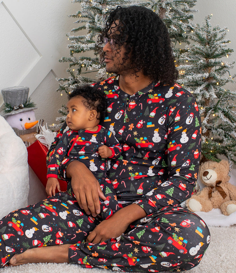 Woman and child wearing matching Christmas-themed pajamas in front of a decorated Christmas tree.