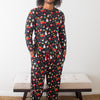 Man wearing a colorful pajama set with a pattern of various items on a white background