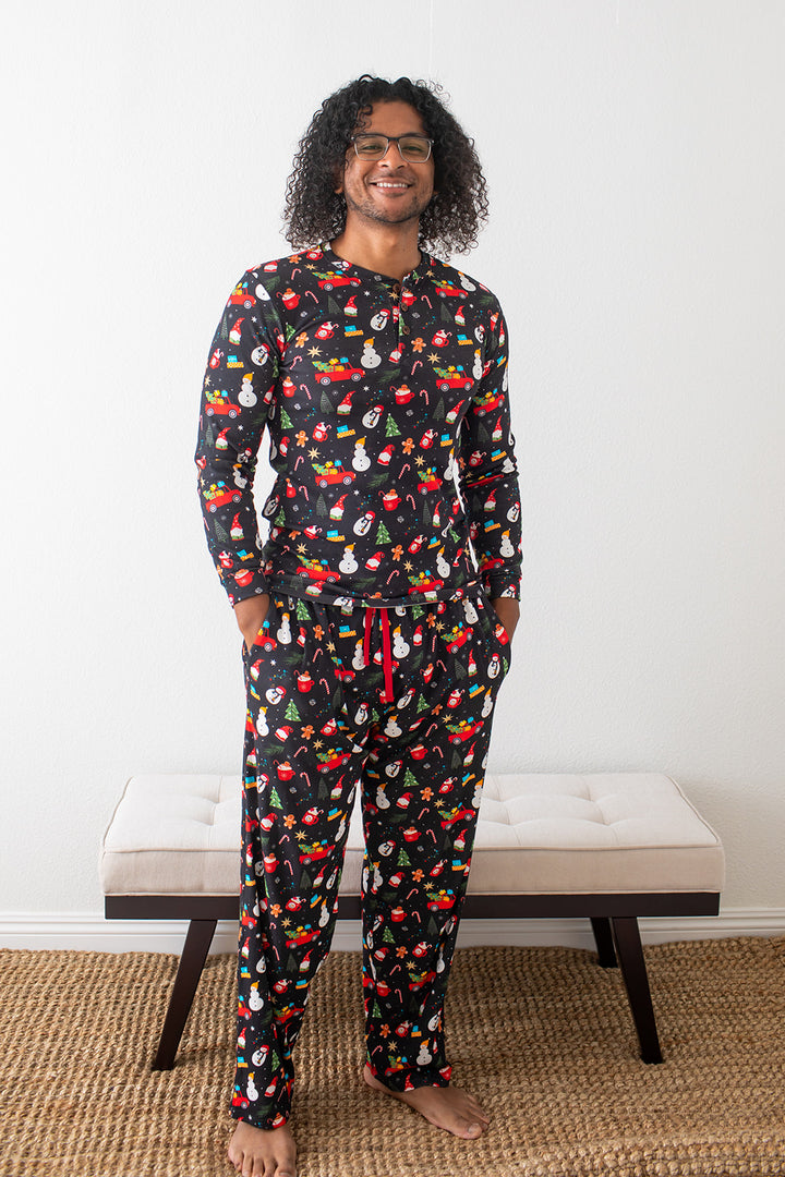 Man wearing a colorful pajama set with a pattern of various items on a white background