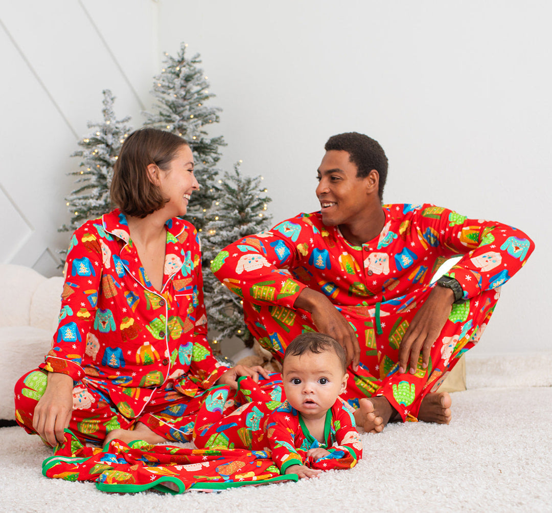 Family in matching red pajamas with Christmas tree in the background