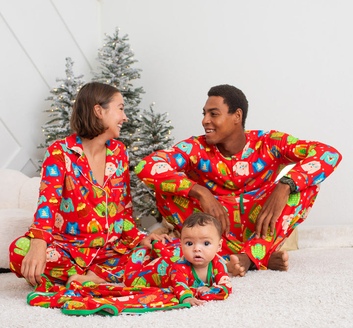 Family in matching red pajamas with Christmas tree in the background