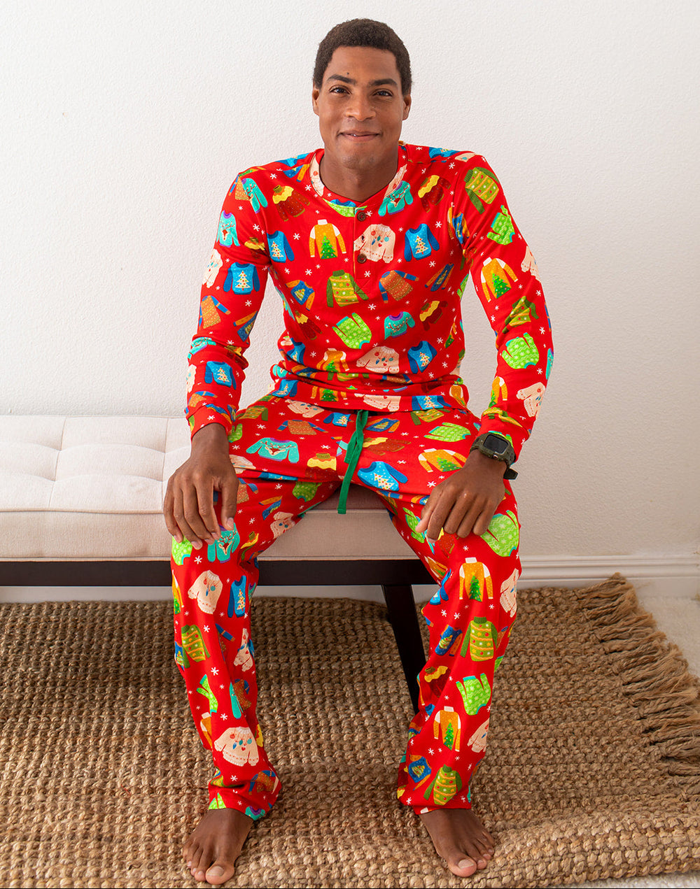 Man wearing a colorful pajama set with a festive pattern sitting on a bench.
