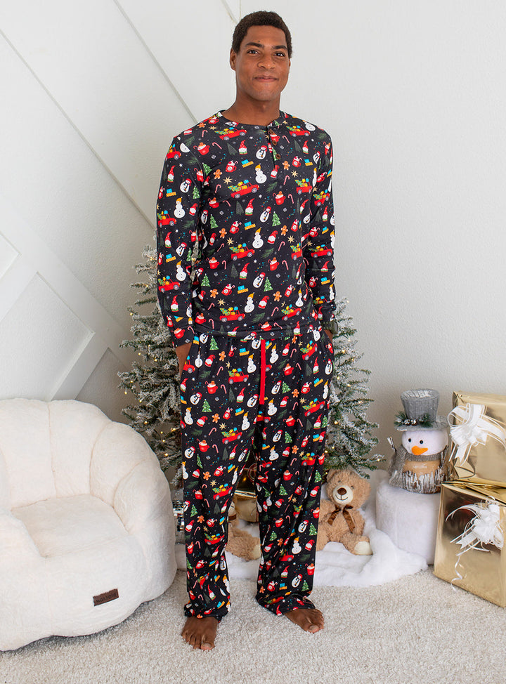 Person wearing festive pajamas standing in a room with a Christmas tree and gifts.