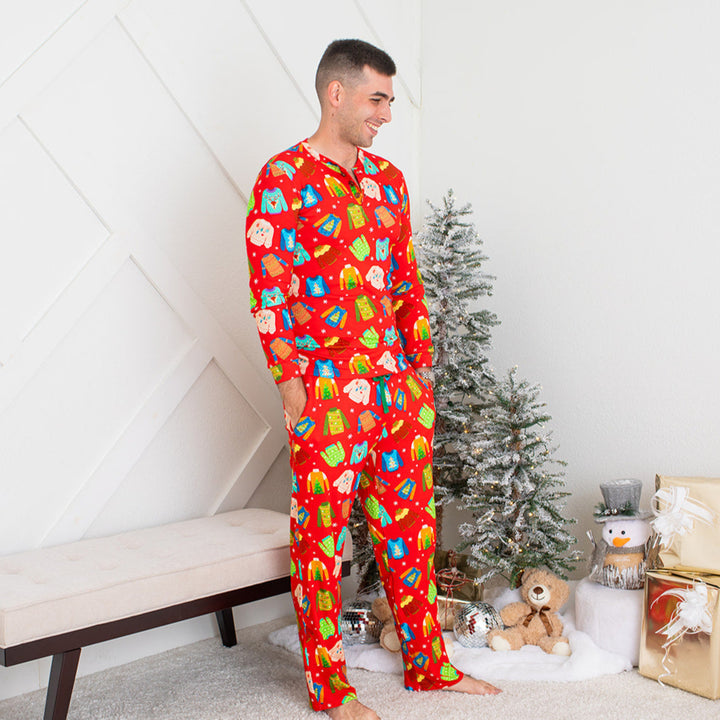 Man wearing festive pajamas in a room with a Christmas tree and gifts.