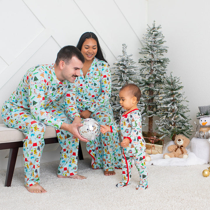 Family in matching pajamas with a Christmas tree and gifts in the background