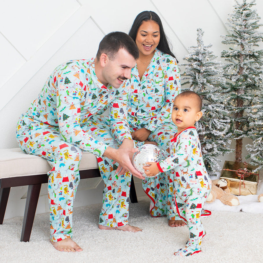 Family in matching pajamas with a Christmas tree and gifts in the background