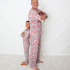 Man and child wearing matching red polka dot pajamas against a white background