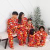 Family of five wearing matching red Christmas pajamas in a living room with a small tree.