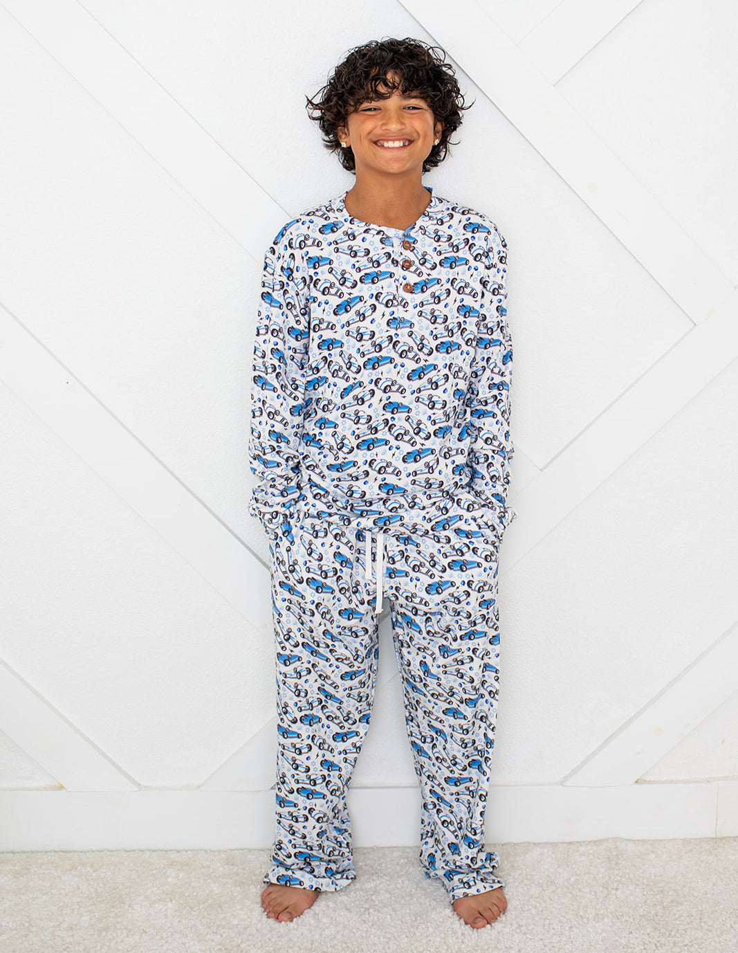 Child wearing a blue and white patterned pajama set on a white background