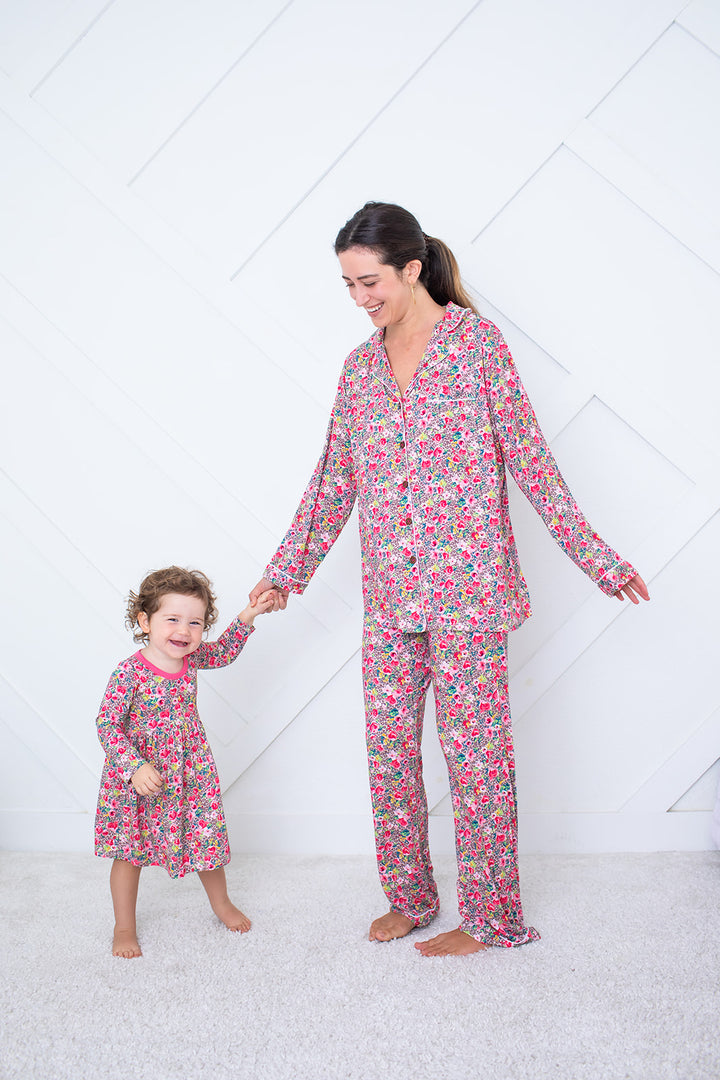 Woman and child wearing matching floral pajamas on a white background