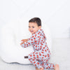 Child wearing a red and gray patterned onesie on a white background