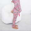 Young girl wearing colorful pajamas sitting on a white bean bag chair.