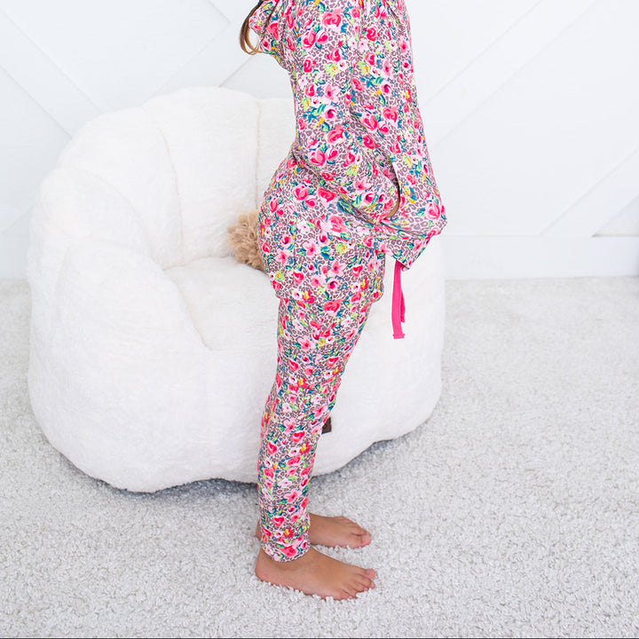 Young girl wearing colorful pajamas sitting on a white bean bag chair.