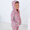Child wearing a colorful floral onesie against a white background