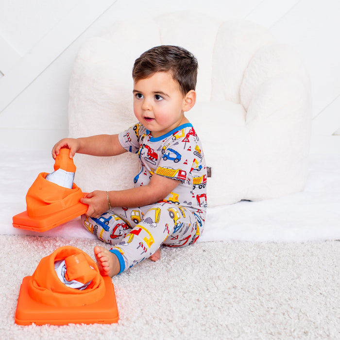 Child playing with orange toys on a white couch