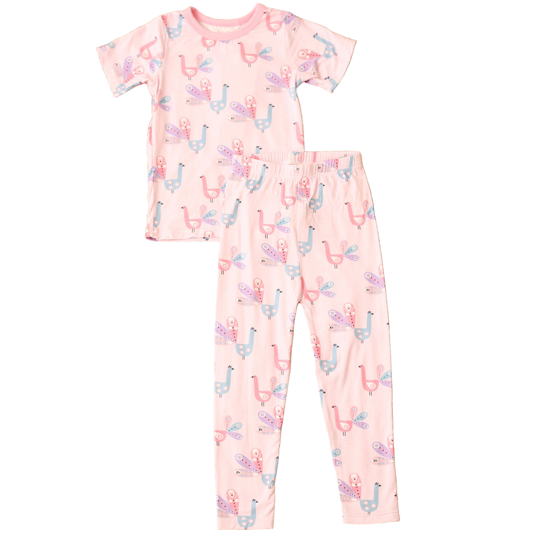 Children's pajama set with pink and white pattern on a textured brown surface