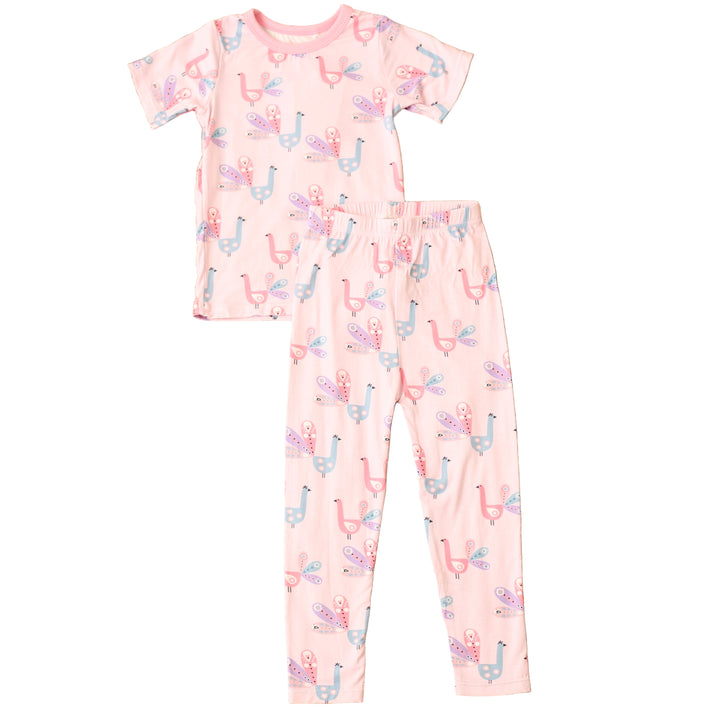 Children's pajama set with pink and white pattern on a textured brown surface