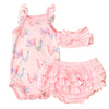 Pink baby outfit with ruffles on a textured brown surface