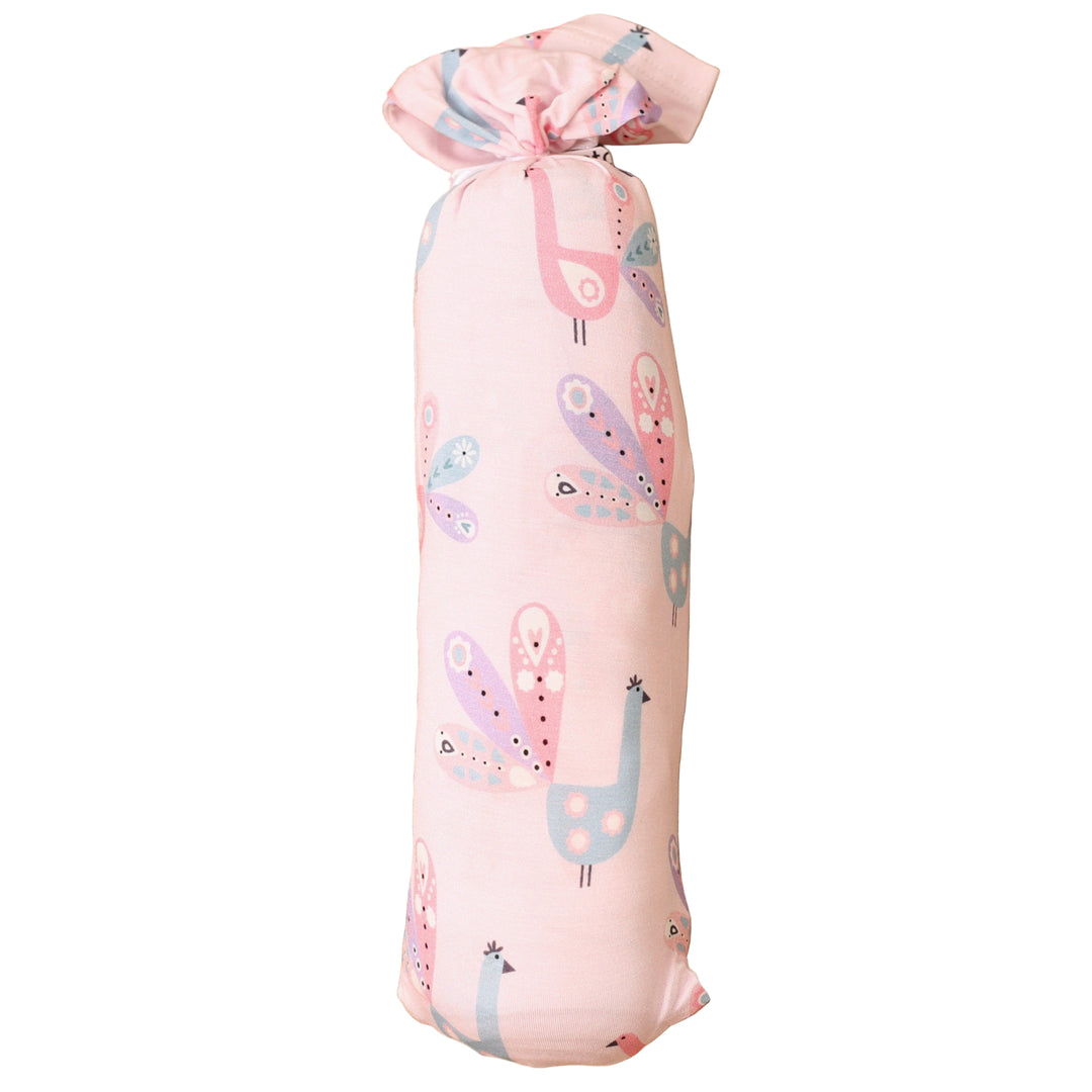 Rolled-up pink fabric with llama pattern on a textured brown surface