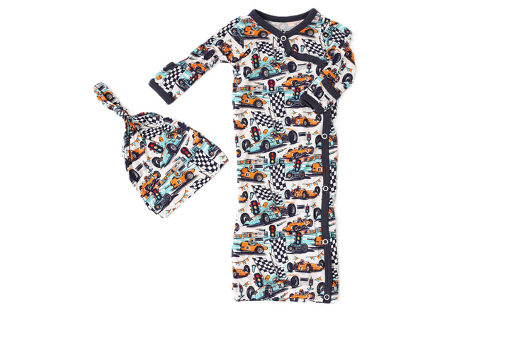 Children's outfit with long-sleeve shirt and hat featuring car and checkered pattern on a white background