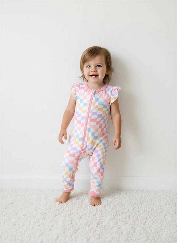 Child wearing a colorful patterned onesie on a white background