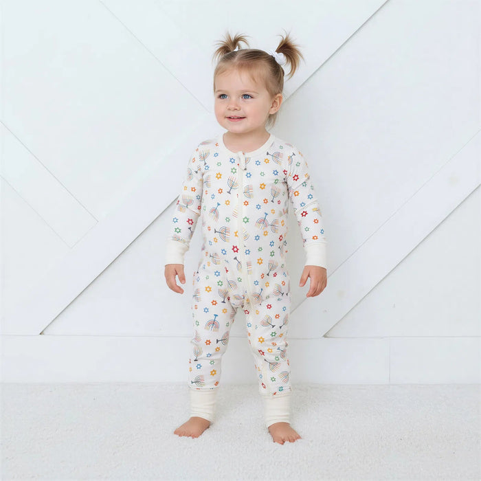 Child wearing a floral onesie on a white background